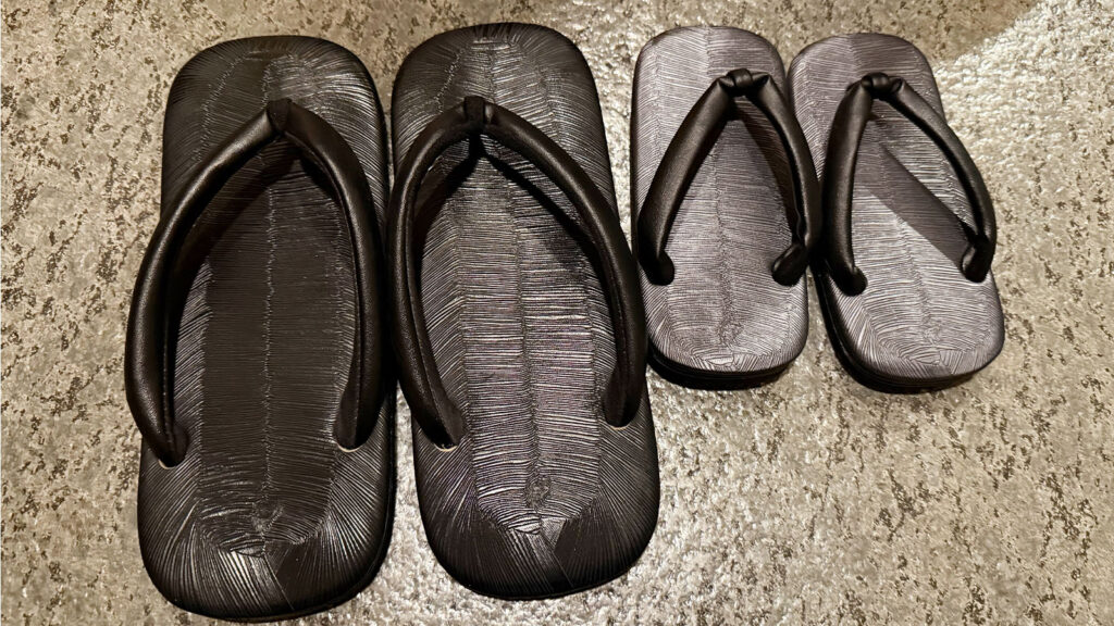 界 秋保の客室サンダル｜大人用と子ども用が並ぶ黒い草履タイプの室内履き