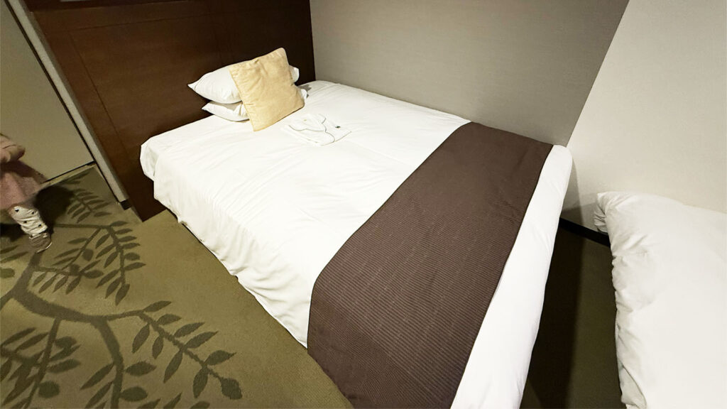 ホテルメトロポリタン仙台のスモールツイン客室のメインベッド。壁側に寄せられており、子どもとの添い寝もしやすい配置。